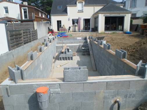 Construction totale d'une piscine de 45 M3 comprenant petit bassin et grand bassin, escaliers et bac a volet roulant.