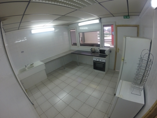 cuisine, double évier, micro-ondes, four, grand frigo et petit frigo.