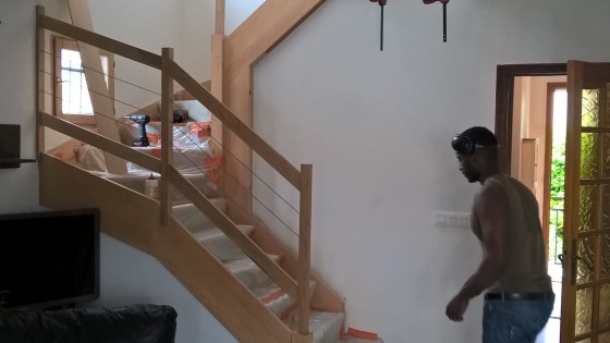 Remplacement d'une rambarde d'escalier dans un pavillon de banlieue. Chêne massif et câble inox. Fabrication préalable en atelier