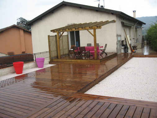 Terrasse en pin autoclave marron sur plusieurs niveaux et pergola en bois.