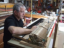 Réglage d'une mécanique de piano à queue Bôsendorfer en atelier.