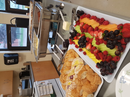 breakfast buffet: fresh sliced fruit, assorted Danish and croissants, scrambled eggs, breakfast sausage and bacon, homefries